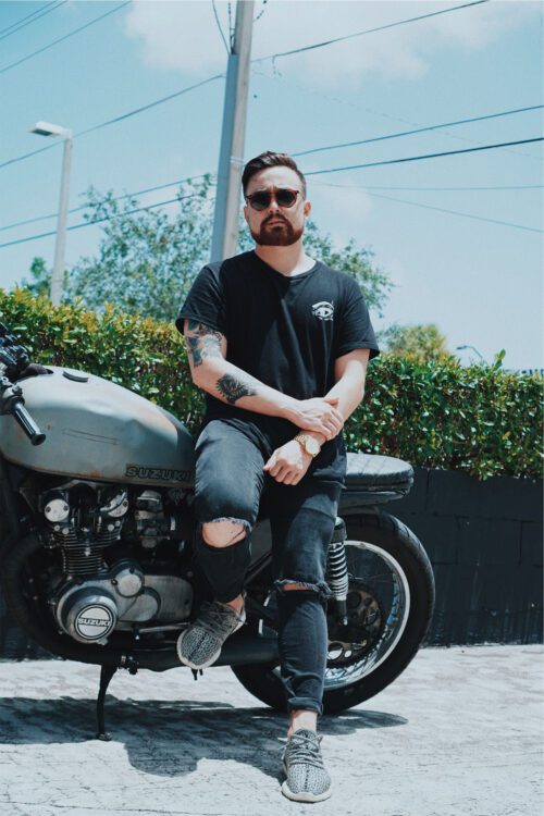 A man sitting on the back of his motorcycle.
