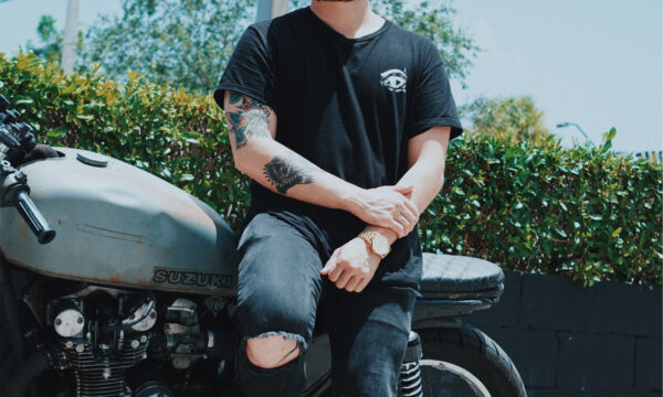 A man sitting on the back of his motorcycle.