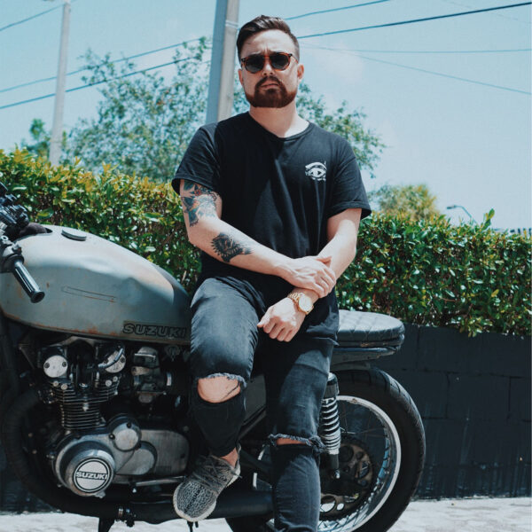 A man sitting on the back of his motorcycle.
