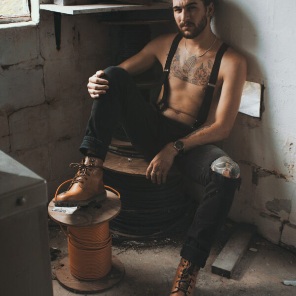 A man sitting on the ground with his feet up.