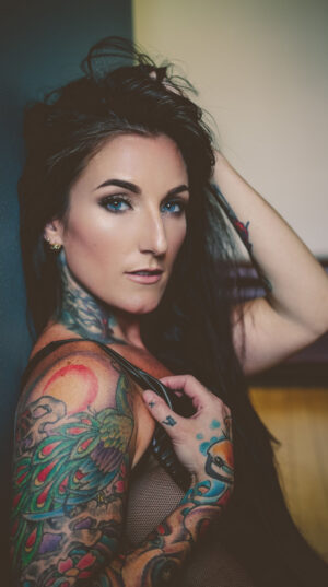 A woman with tattoos on her arms and shoulder.