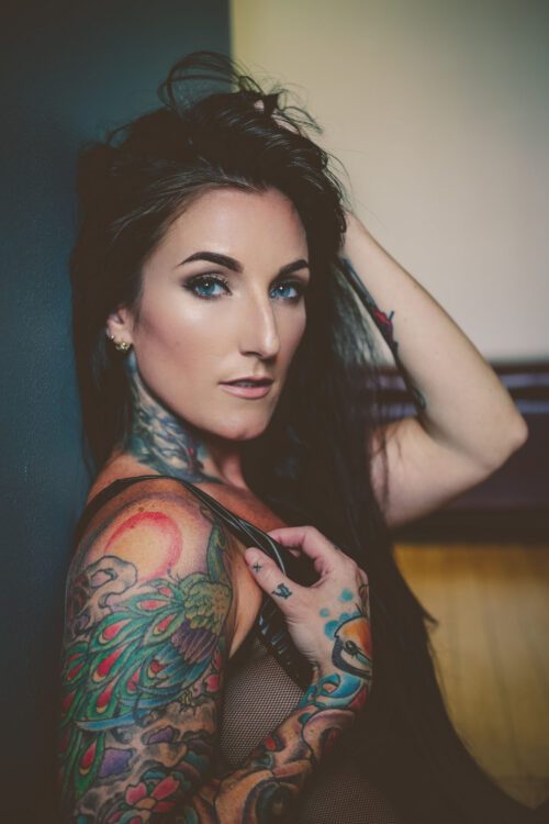 A woman with tattoos on her arms and shoulder.
