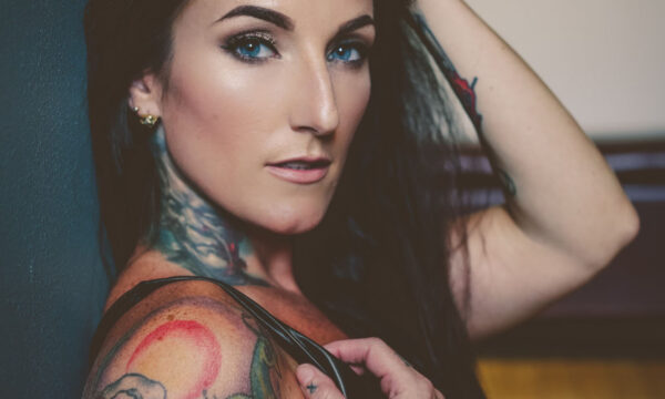 A woman with tattoos on her arms and shoulder.