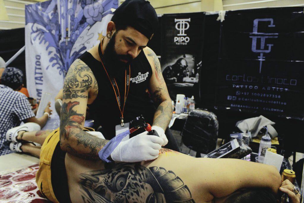 A man with tattoos on his arms and legs.