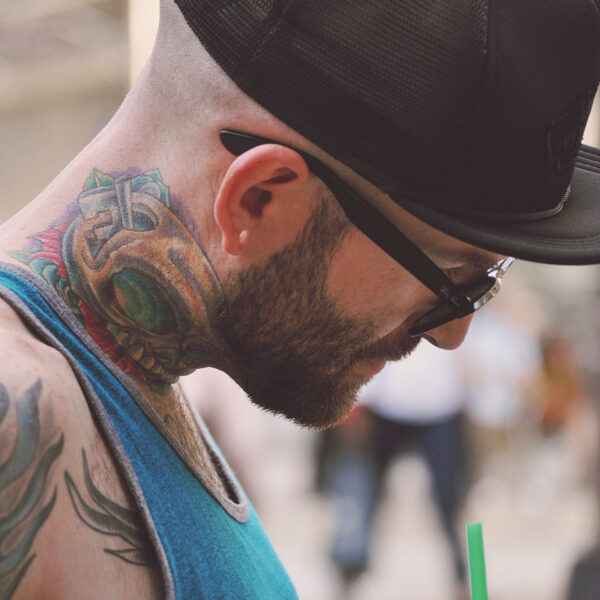 A man with tattoos and glasses on his face.