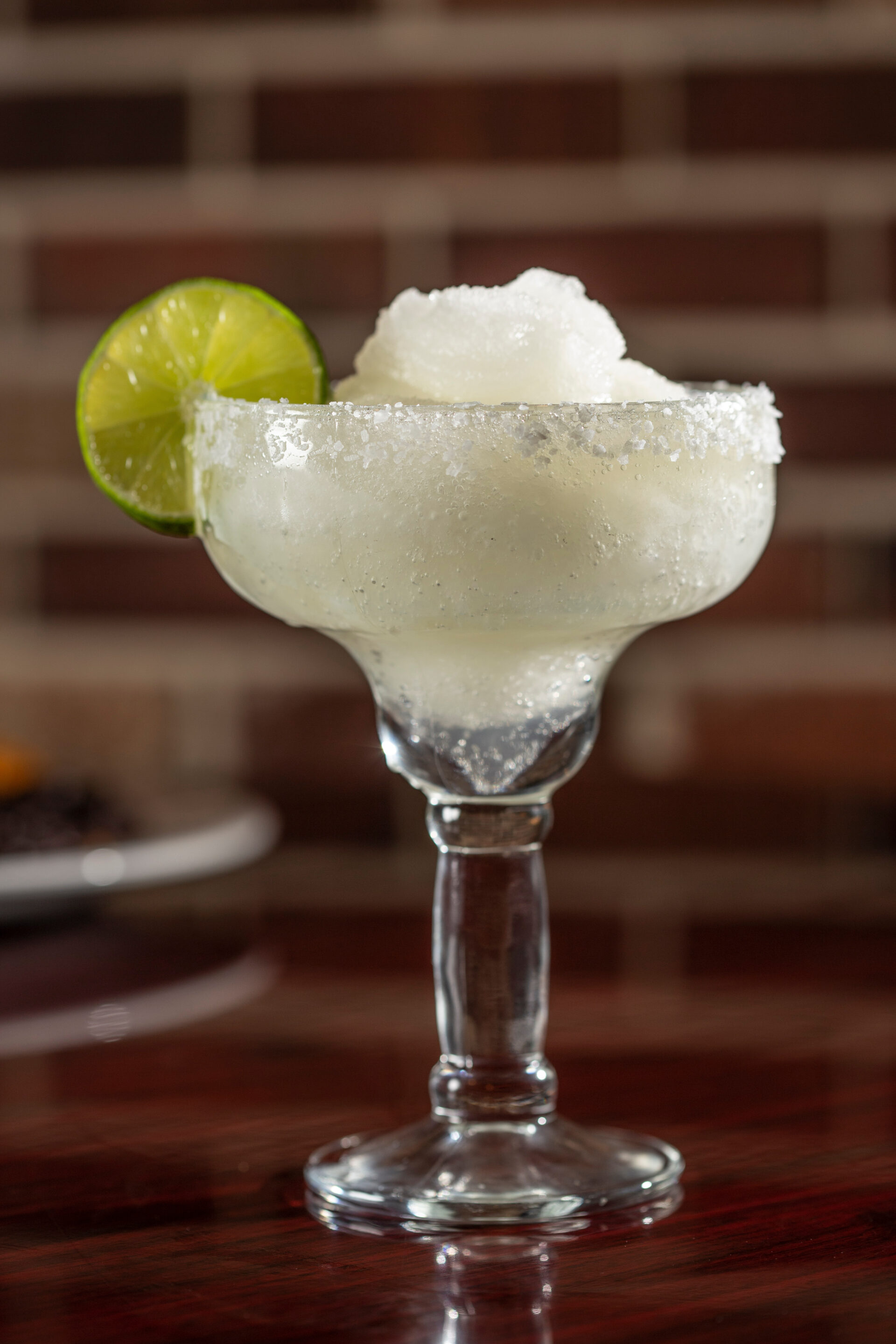 A glass of ice cream with a lime slice on top.