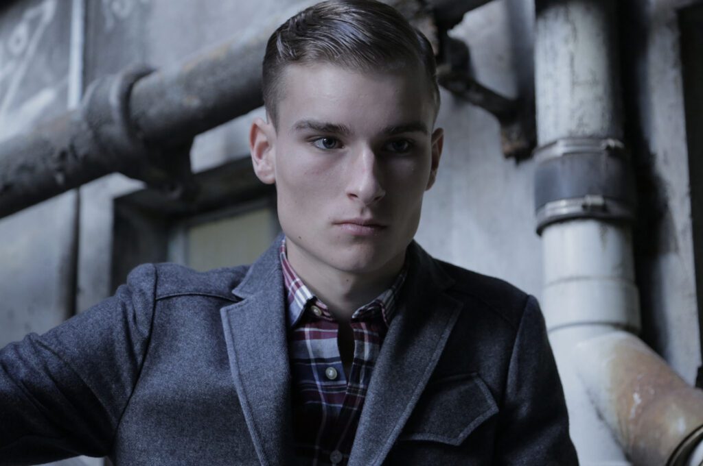 A man in a jacket and plaid shirt