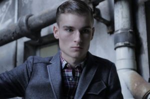 A man in a jacket and plaid shirt