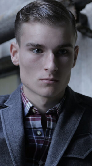 A man in a jacket and plaid shirt