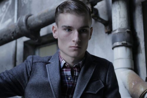 A man in a jacket and plaid shirt