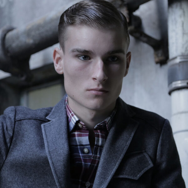 A man in a jacket and plaid shirt