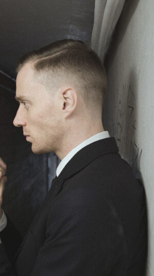 A man in suit and tie holding a cell phone.