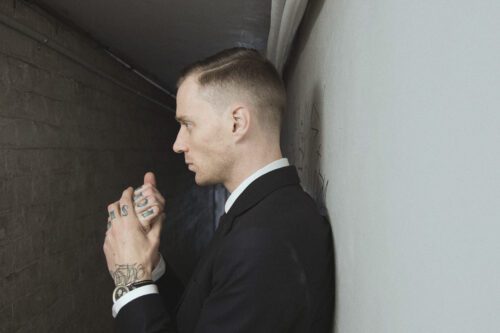 A man in suit and tie holding a cell phone.