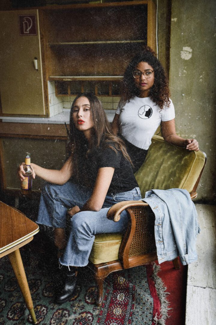 Two women sitting on a chair in a room.