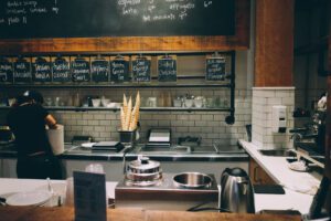 A kitchen with chalkboard and wooden shelves