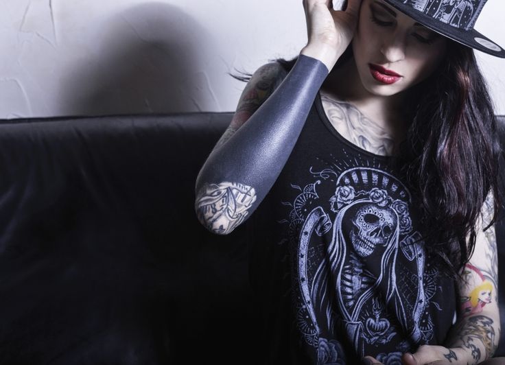 A woman with tattoos on her arm and shoulder.