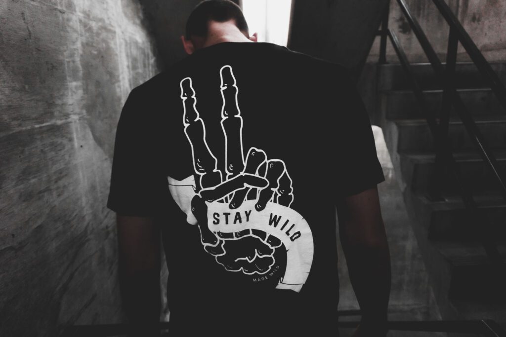 A man wearing a black shirt with a hand sign.