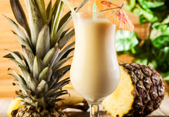 Pina Colada over wooden background garnished pineapple